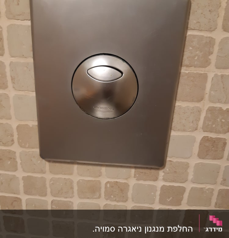 לחצן נירוסטה להדחת אסלה על קיר אריחים